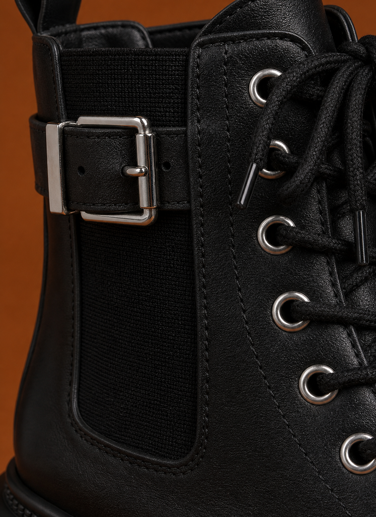 Close-up of buckle strap and lace-up details on women's ankle boot with chunky sole