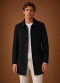 Front view of men's long overcoat on a mannequin showing tailored silhouette
