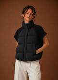 Front view of women's puffer vest with knit shoulder panels on a mannequin