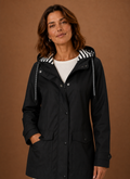 Front view of women's hooded trench coat on mannequin showing hood and streamlined front silhouette