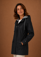 Side profile of women's hooded trench coat highlighting sleeve length and straight fit