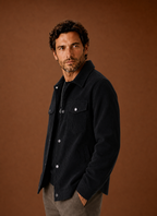 Side profile of a men's crew neck knit sweater showing shoulder and sleeve fit