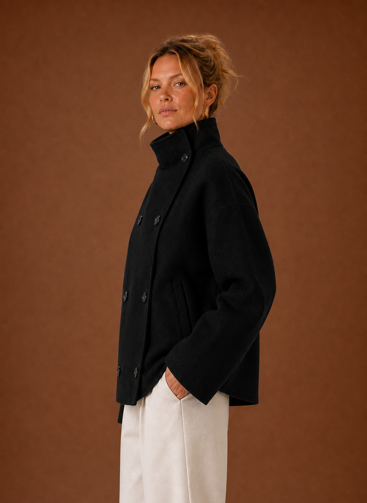 Side view of a women's funnel neck jacket in black