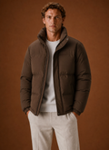 Front view of a men's oversized puffer jacket on a mannequin, showing the relaxed fit