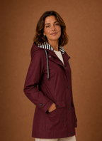 Side profile of women's hooded trench coat highlighting sleeve length and straight fit