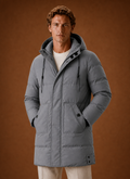 Front view of men's hooded puffer parka jacket in grey showing puffer channels and attached hood
