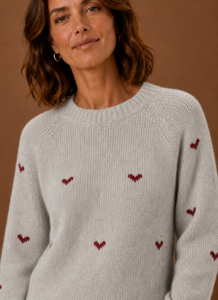 Close-up of knit texture and heart print detail on the crew neck sweater