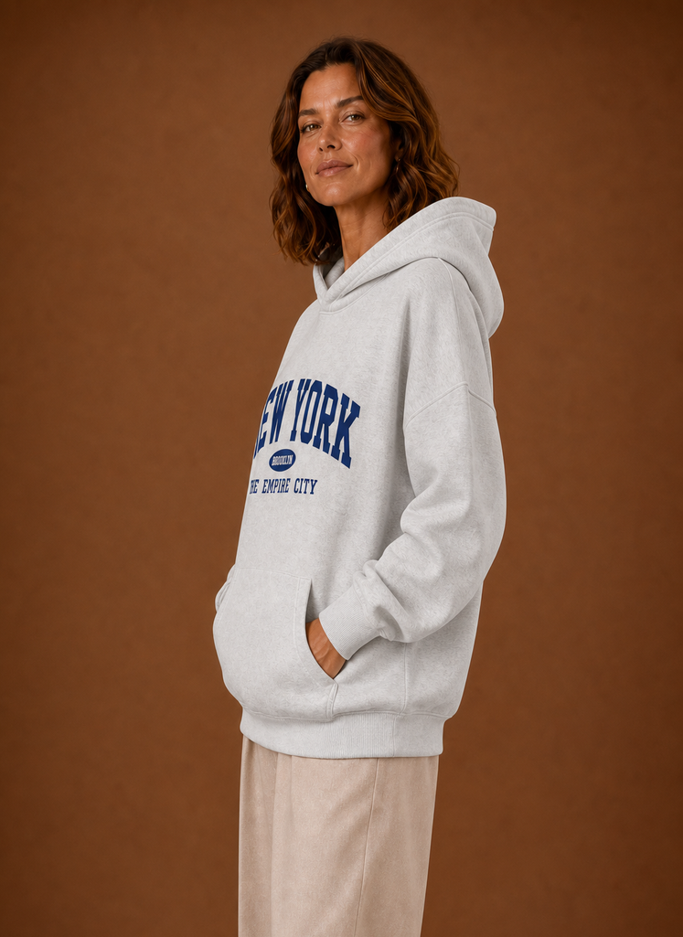 Side profile of oversized women's pullover hoodie showing hood and relaxed fit