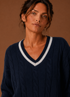 Close-up of cable knit texture and V-neck seam detail