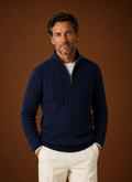 Front view of men's cable knit quarter-zip sweater with mock neck on neutral background