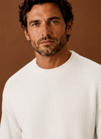Close-up of ribbed neckline and cuff details on a men's white crewneck pullover
