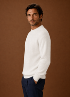 Side profile of a men's white crewneck pullover displaying the shoulder and sleeve fit