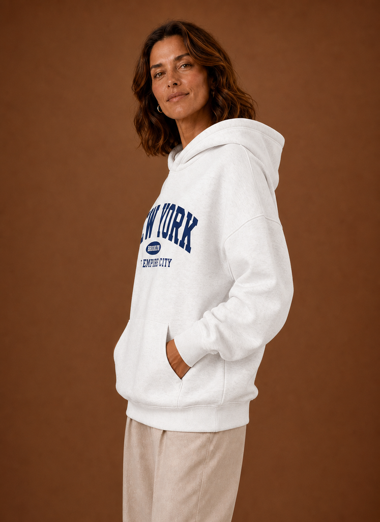 Side profile of oversized women's pullover hoodie showing hood and relaxed fit